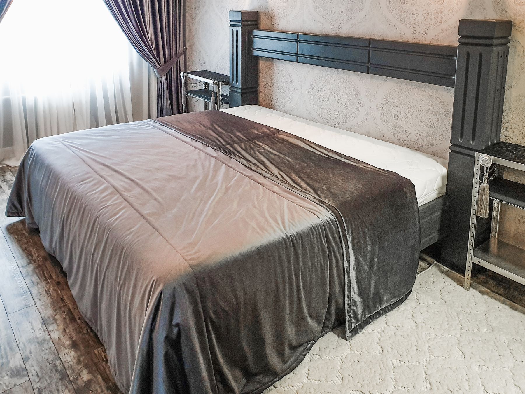 A gray comforter spread across a neatly made bed